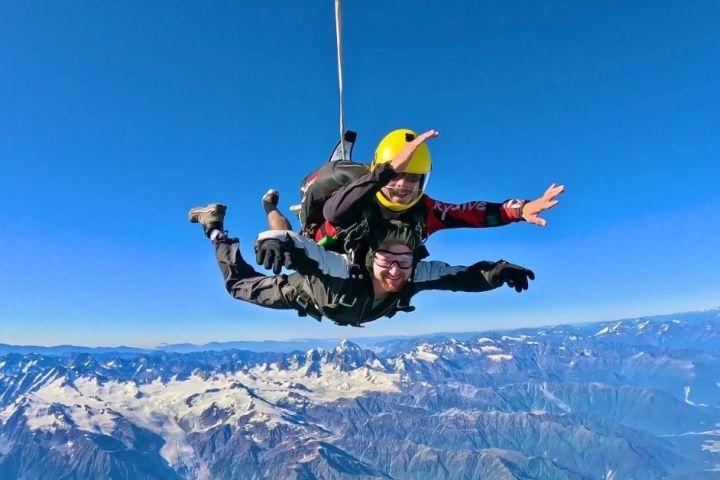 a man flying through the air on a snow covered mountain