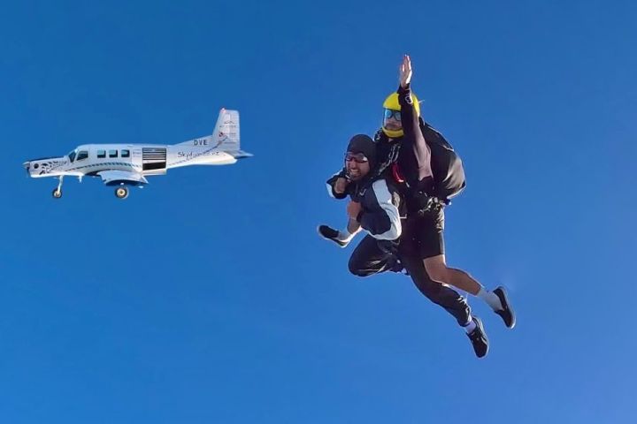 a man flying through the air on a clear blue sky