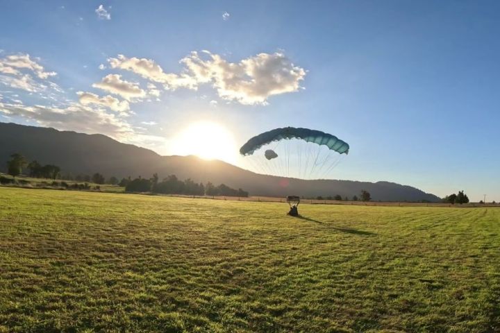 a large green field with a mountain in the background