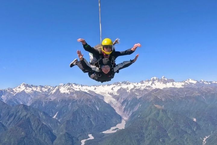 a man flying through the air on top of a mountain