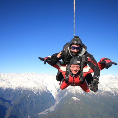 a man flying through the air on a snow covered mountain
