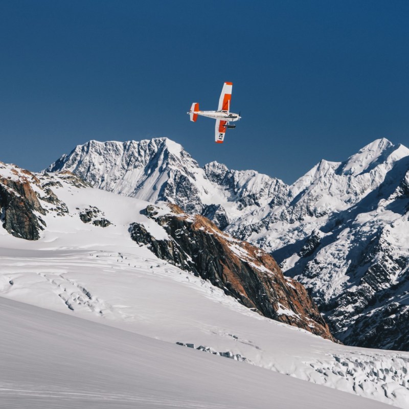 a man flying through the air on a snow covered mountain