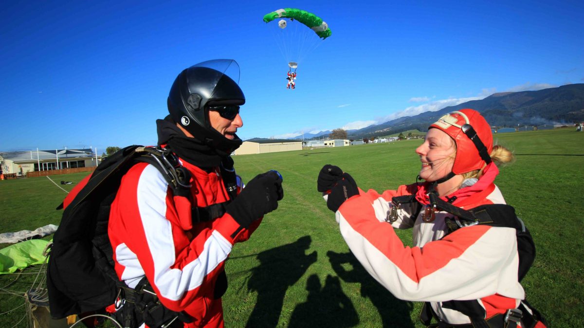Skydive-Abel-Tasman-by-INFLITE-431 a group of people that are standing in the grass