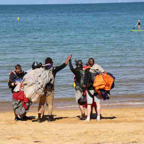 a group of people on a beach near a body of water