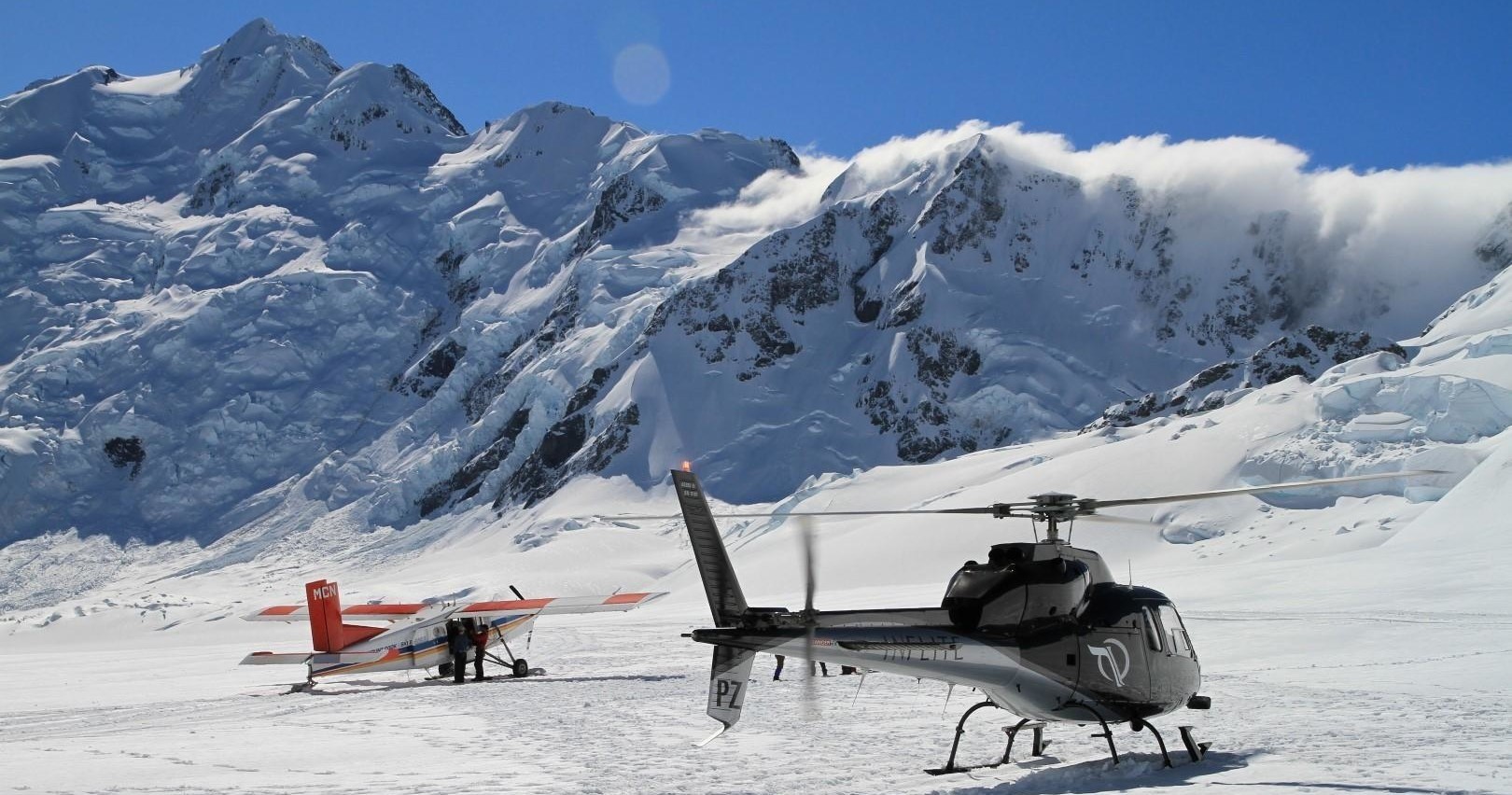 a group of people standing on top of a snow covered mountain