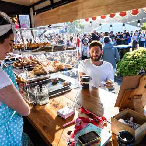 a person sitting at a table with a hot dog