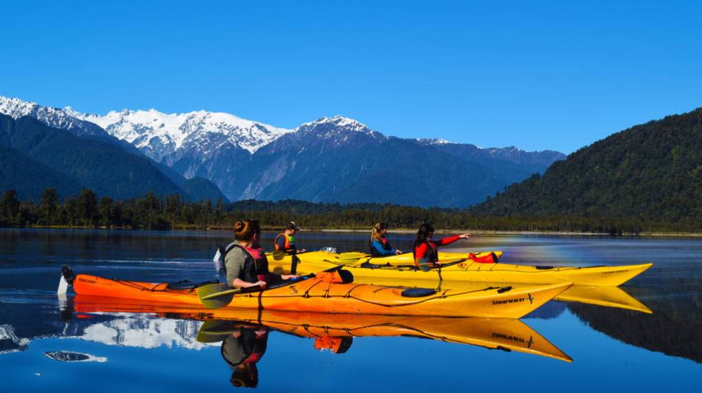 Lake-Mapourika-Glacier-Country-Kayaks_optimized a plane sitting on top of a mountain lake