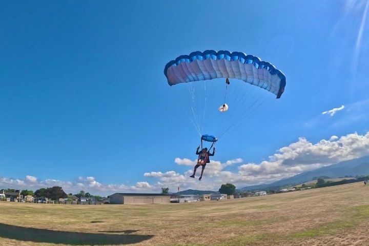 a person flying through the air on a parachute