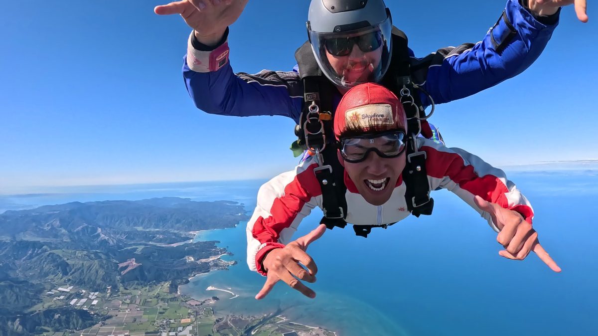 a tandem skydive flying through the air over south and north island