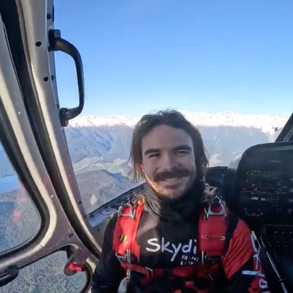skydiver in helicopter with large windows showing scenery of franz josef