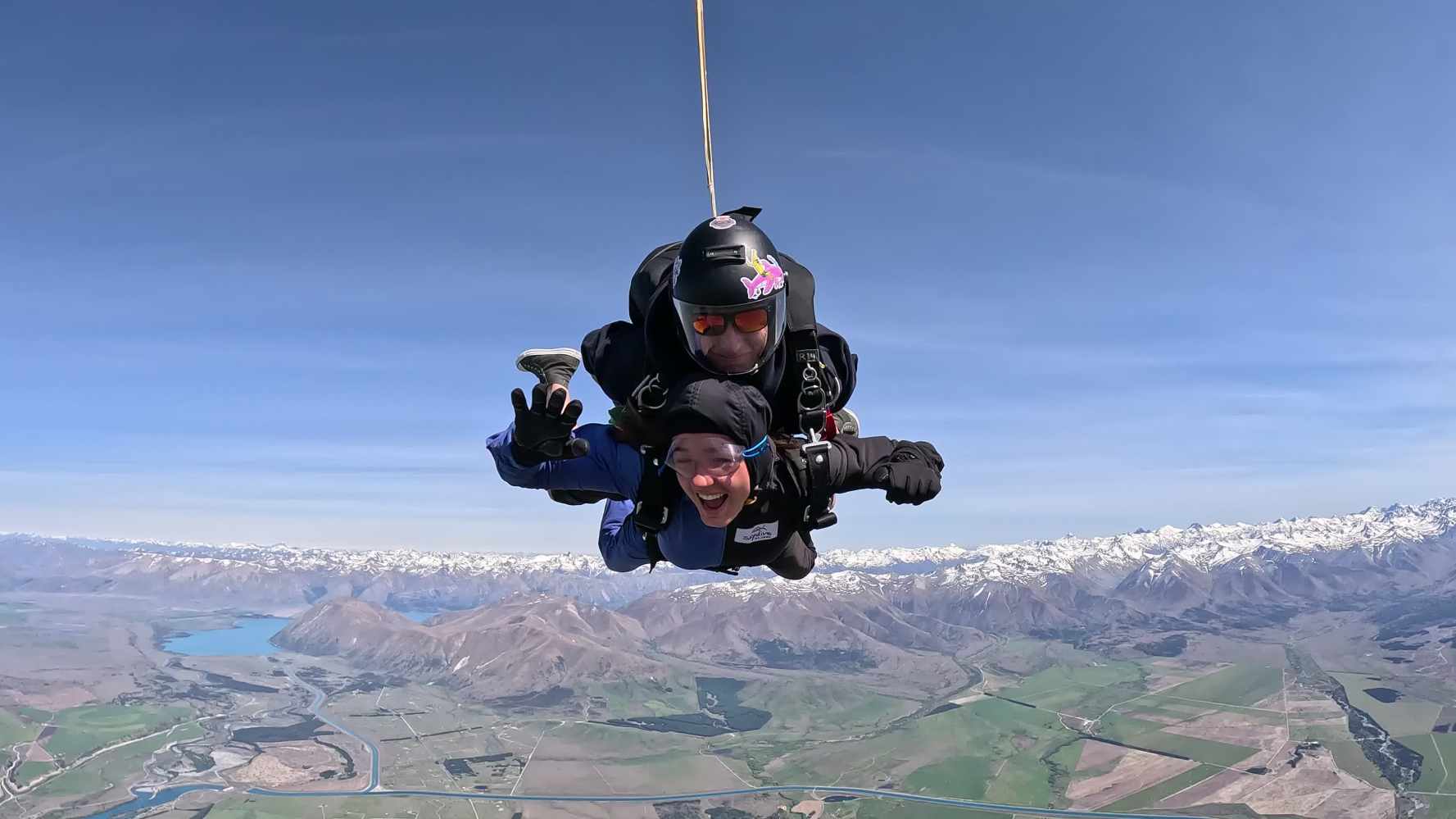 men skydive over mountains and lakes