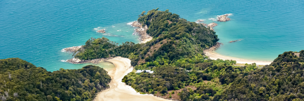 Aerial view of lush green peninsula with sandy beaches and turquoise waters.